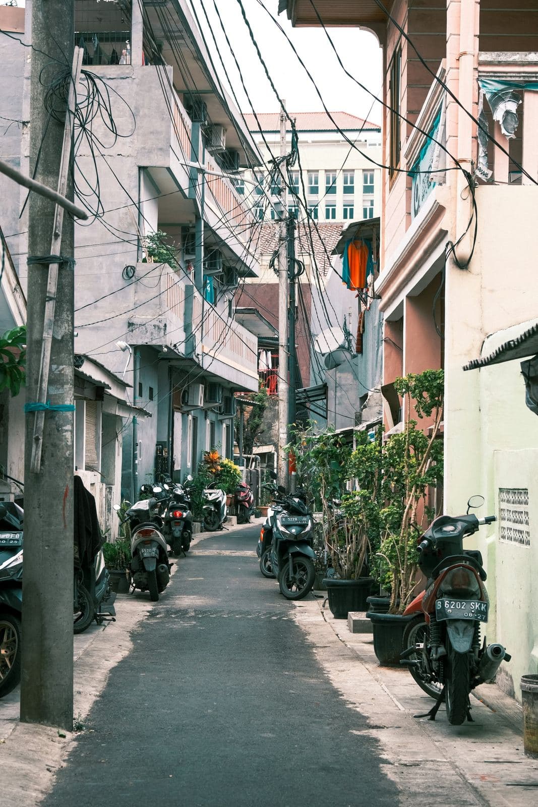 Gang perumahan di Jakarta dengan sepeda motor terparkir